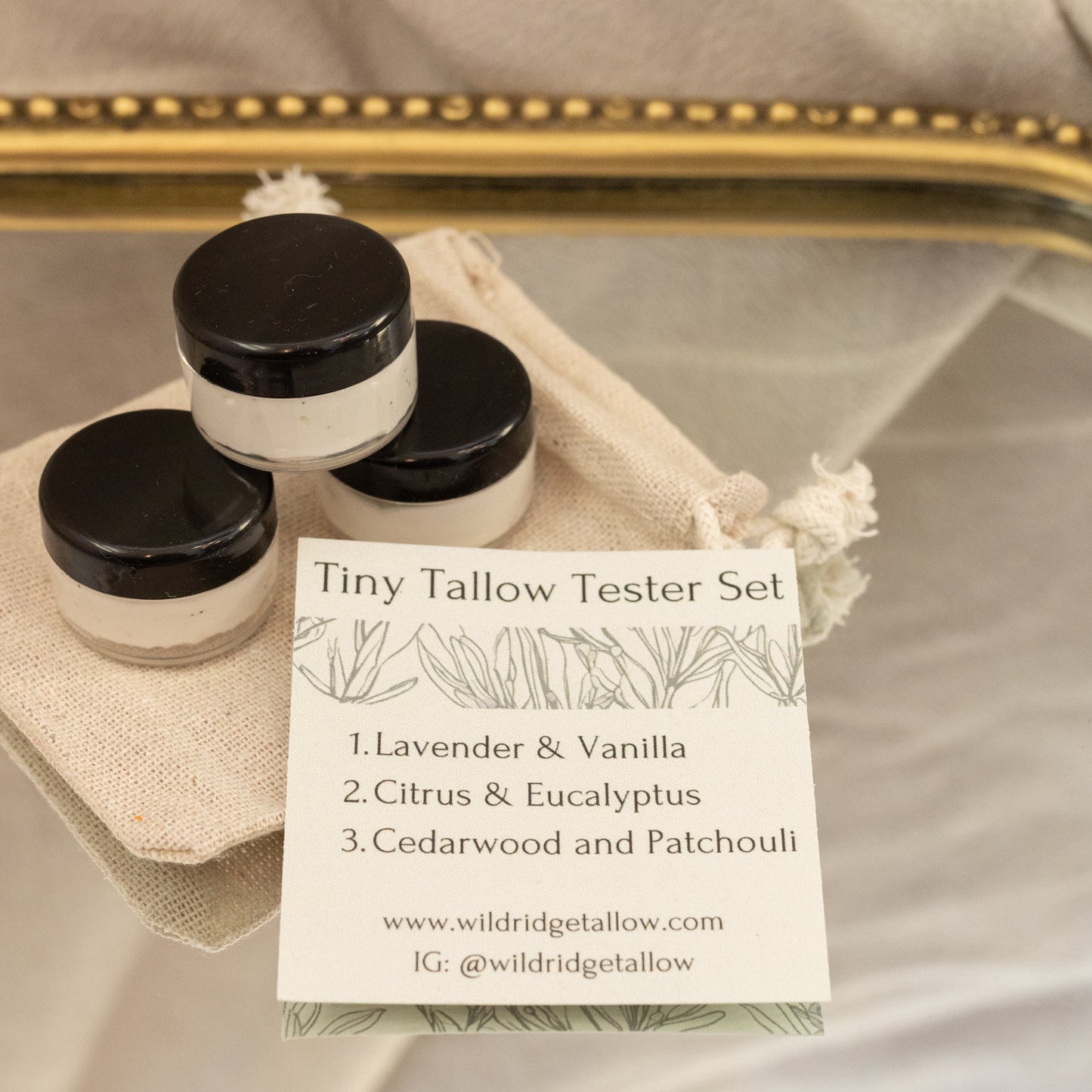 Tin Tallow Tester Set with three small containers and a business card on a reflective surface.
