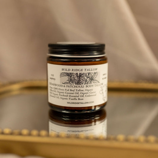 Jar of Wild Ridge Tallow balm on a reflective surface with a neutral background