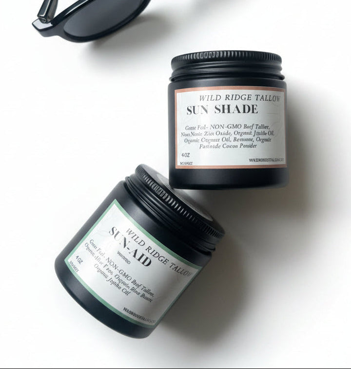 Two jars of sun care products and a pair of sunglasses on a textured fabric background